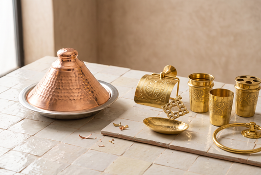 Red copper tajine next to engraved yellow brass bathroom accessories