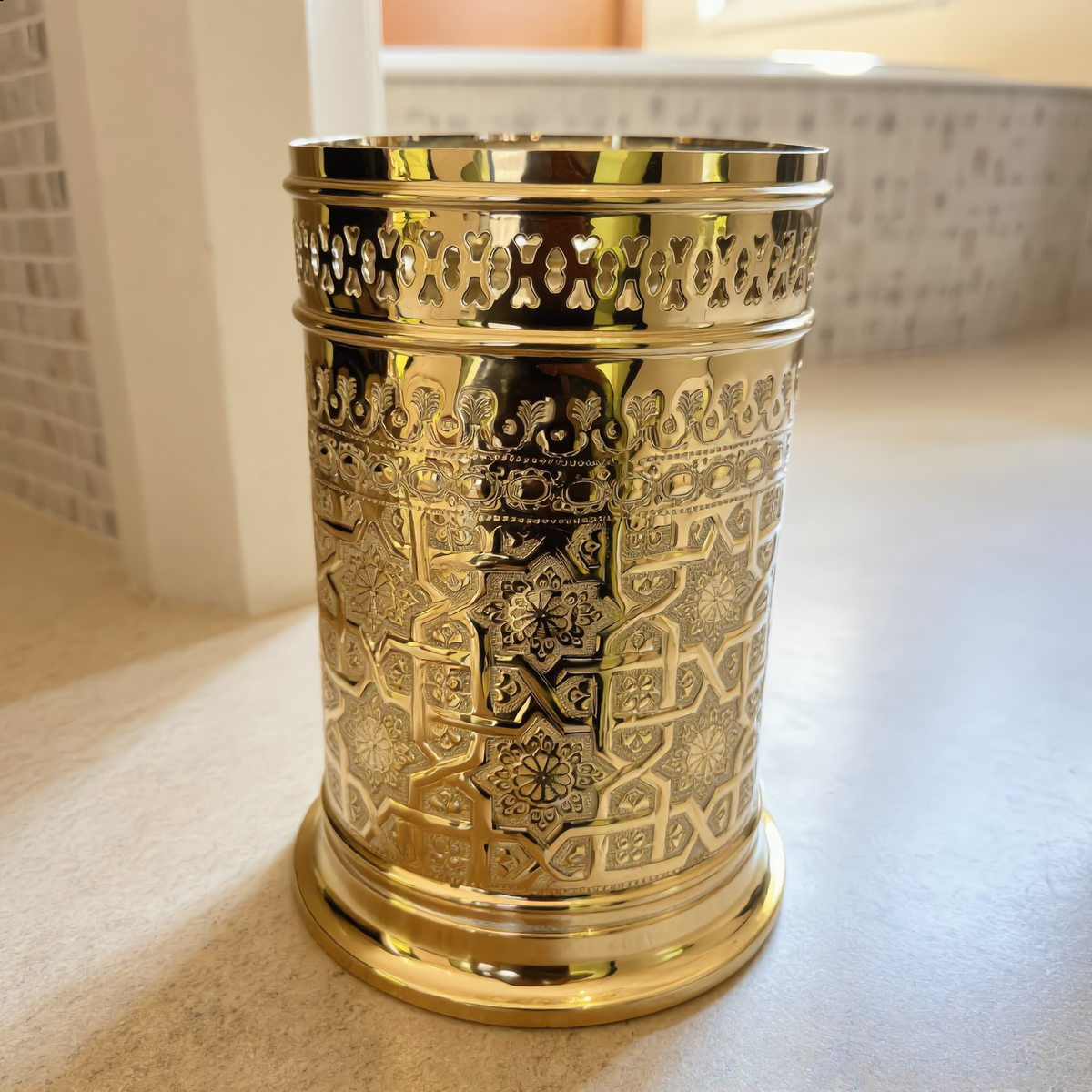 Engraved brass bathroom bin on a travertine floor, Moroccan riad bathroom, Cuivra