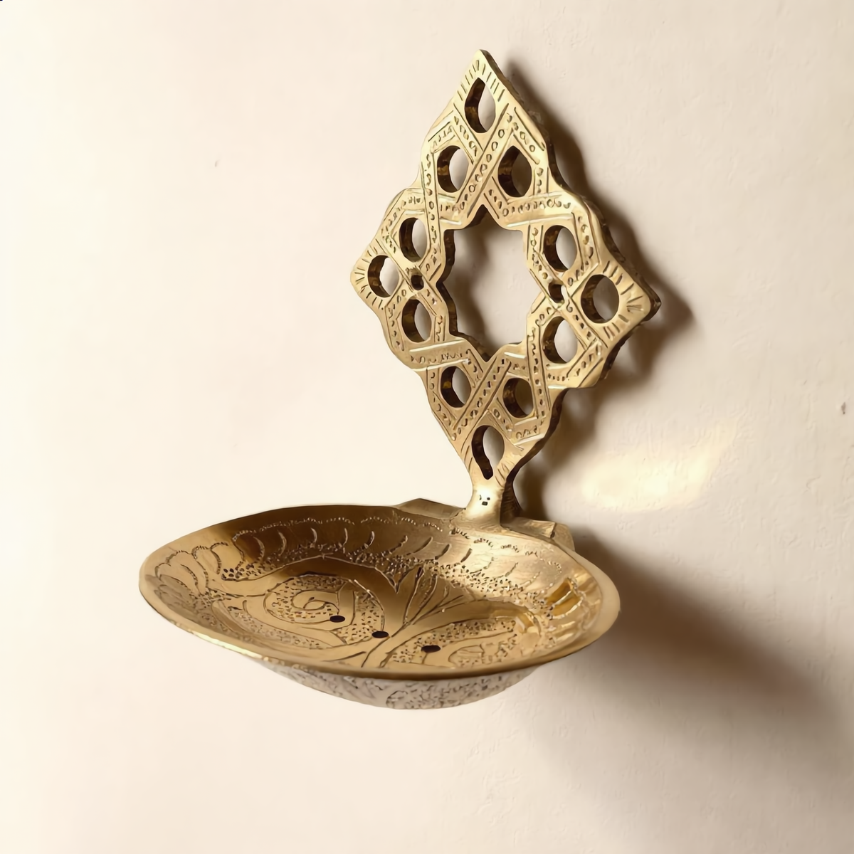 Brass wall soap dish with pierced Moroccan back plate on a cream wall