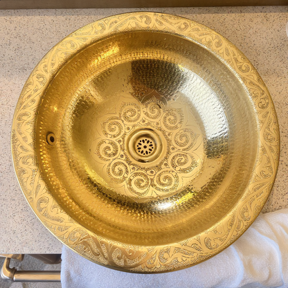 Hand-engraved Moroccan brass vessel sink on a travertine vanity, top view, Cuivra