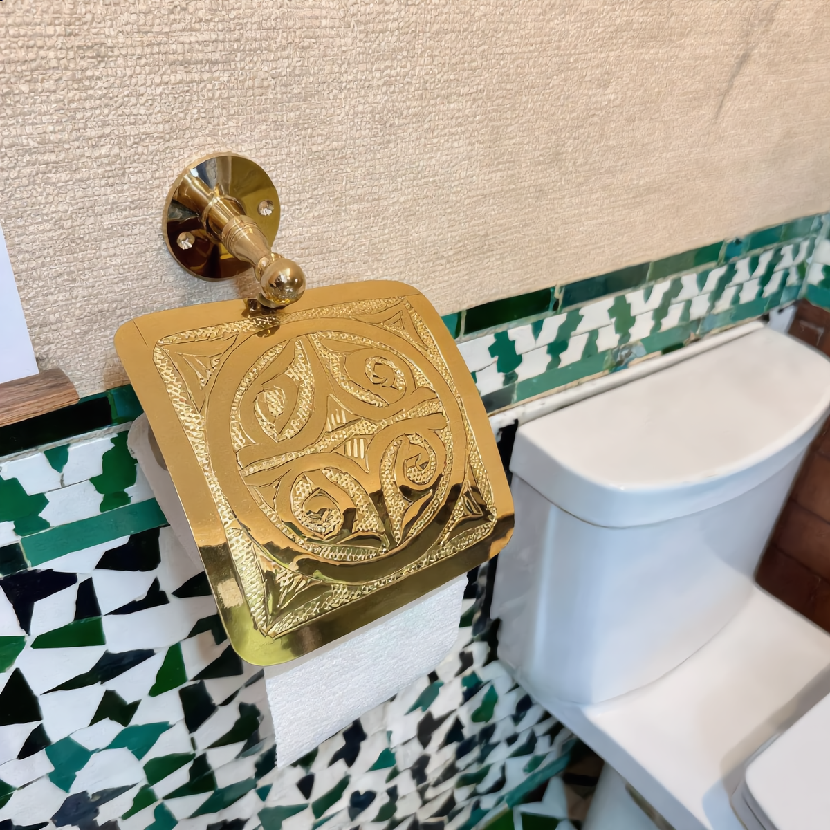 Brass toilet paper holder in a Moroccan bathroom with zellige