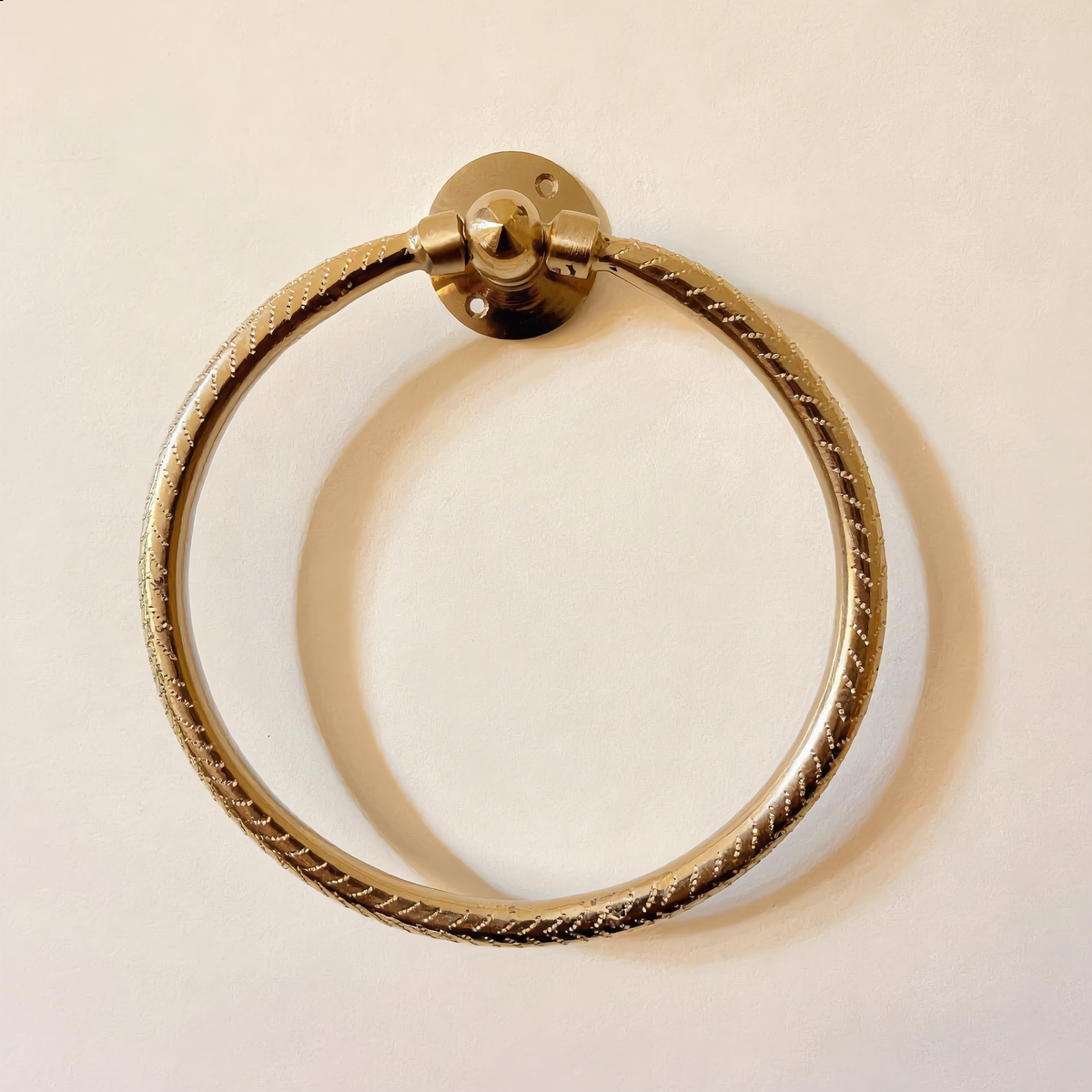 Moroccan engraved brass towel ring mounted on a cream wall, Cuivra